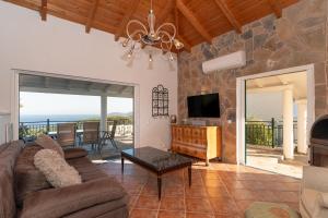 a living room with a couch and a tv at Skatza Ocean Crest in Kamária