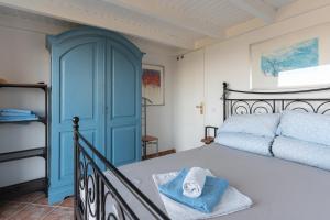 a bedroom with a bed and a blue door at Skatza Ocean Crest in Kamária
