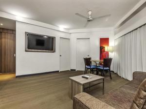 ein Wohnzimmer mit Sofa und Tisch in der Unterkunft Novotel Darwin CBD in Darwin