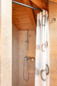a bathroom with a shower with a shower curtain at Skatza Ocean Crest in Kamária +51 photos