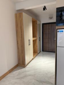 an empty kitchen with wooden cabinets and a refrigerator at Azur Properties 76 in Shkorpilovtsi