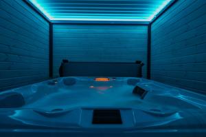 a blue bath tub in a room with a blue light at Domki SUNSET Bałtycka in Dąbki +37 photos