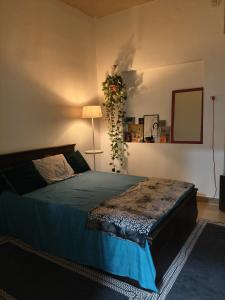 a bedroom with a bed with a lamp and a plant at The Culture House in Mumbai