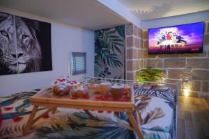 a living room with a table and a tv at Moonlight Jungle Suit Luxury experience in Avola