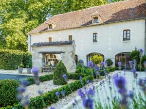 a house with purple flowers in front of it at Hotel De Bourbon Grand Hotel Mercure Bourges in Bourges