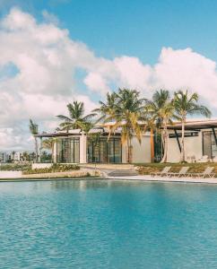 a building with palm trees in front of a pool at Villa Divina in Punta Cana