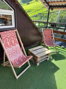 two lawn chairs and a bench on a porch at Kesane in Jut'a