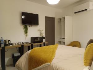 a bedroom with a bed and a tv on the wall at Chambre indépendante in Le Vigan