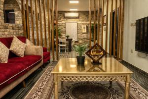 ein Wohnzimmer mit einem roten Sofa und einem Tisch in der Unterkunft فيلا وشاليه نسيم لافا in Rayyis