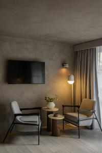 a living room with two chairs and a tv at Casa Levora in Mexico City