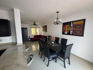 a dining room with a black table and chairs at Casa Flamingo in Bucerías