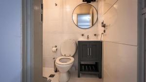 a bathroom with a toilet and a mirror at Escobar Apart CENTRO in Belén de Escobar