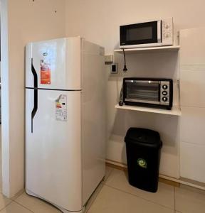 a white refrigerator in a kitchen with a microwave at Escobar Apart CENTRO in Belén de Escobar