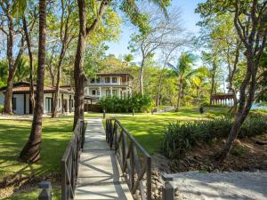 a walkway leading to a house with palm trees at Reunion Wellness Resort & Retreats in Playa Danta