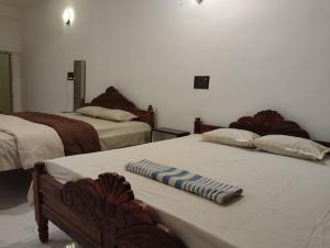 a room with two beds and a table with towels on it at SHARDA PALACE Deoghar in Deoghar