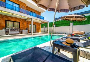 a swimming pool with two chairs and an umbrella at Olive villas in Fethiye