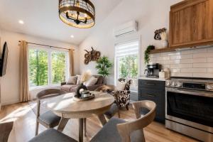 a kitchen and living room with a table and chairs at Condo and Spa - Le Saloon Nordik in Saint Come