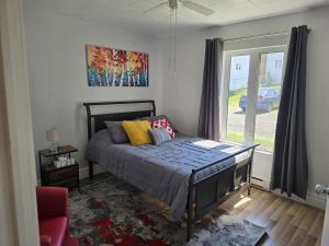 a bedroom with a bed and a window at Le Repere, Beach, Whales, and Ferry in Saint-Siméon