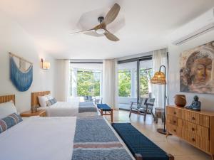 a bedroom with two beds and a ceiling fan at Reunion Wellness Resort & Retreats in Playa Danta +64 photos