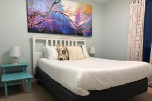 a bedroom with a bed with a painting on the wall at Glen Eagle Kingfisher Suite in Colorado Springs