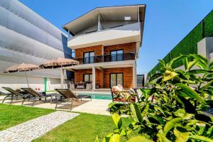 a house with a pool and some chairs and umbrellas at Olive villas in Fethiye