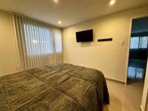 a bedroom with a bed and a flat screen tv at House51 "ubicado a solo 3 cuadras de la playa en pleno centro de Rada Tilly" in Rada Tilly +14 photos