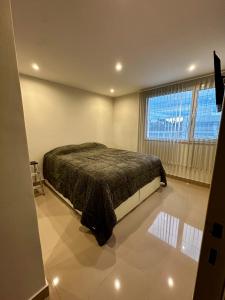 a bedroom with a bed and a large window at House51 "ubicado a solo 3 cuadras de la playa en pleno centro de Rada Tilly" in Rada Tilly