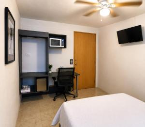 a bedroom with a bed and a desk with a computer at Barrio Inn Morelos in Monterrey