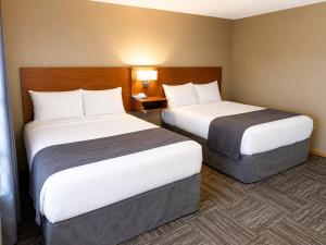 a room with two beds in a hotel room at Ste Anne Hotel in Sainte Anne-des-Chênes