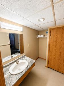 a bathroom with a sink and a mirror at Ste Anne Hotel in Sainte Anne-des-Chênes