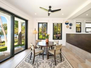 a dining room with a table and chairs and a flat screen tv at Reunion Wellness Resort & Retreats in Playa Danta