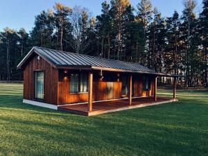 a small wooden cabin in a field of grass at Escape to Nature - Piparmētras in Mērsrags