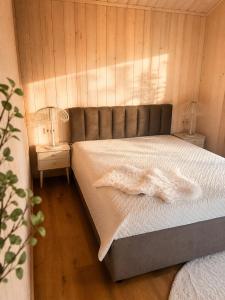 a bedroom with a bed with white sheets and a lamp at Escape to Nature - Piparmētras in Mērsrags