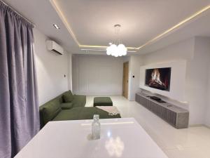 a living room with a green couch and a tv at Pc Luxury 1 bedroom with pool in Lagos