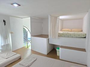 a small white room with a bed in it at Posada Bugambilias in Catemaco