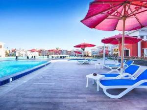 a pool with chairs and umbrellas and a swimming pool at Chalet in sharm el shekh in Sharm El Sheikh