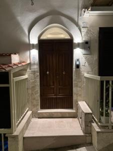 a wooden door in a stone building with stairs at Borgo Bianco in Vieste