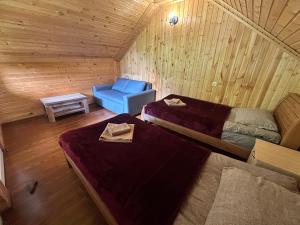 a room with two beds and a blue chair at Kesane in Jut'a