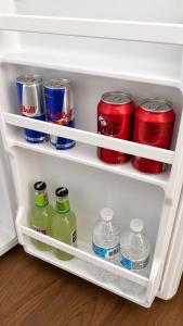 a refrigerator filled with cans and bottles of soda at Alojamiento en Paine cerca Monticello in Hijuela Larga