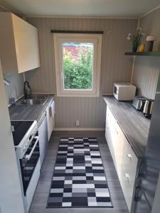 eine kleine Küche mit Schachbrettboden in der Unterkunft Öjavad in Svängsta + 2 Fotos