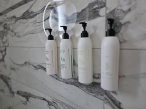 a group of four white bottles on a wall at B&B Lofts Thassos in Skala Rachoniou