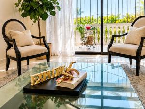 a living room with a glass table with a book on it at Bright & Modern Apartment in Puerto Plata, Secure, and Central! in San Felipe de Puerto Plata