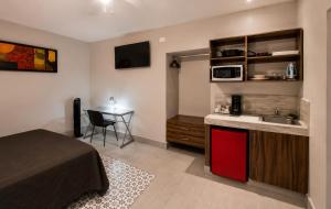 a bedroom with a bed and a desk with a microwave at Barrio Inn Morelos in Monterrey
