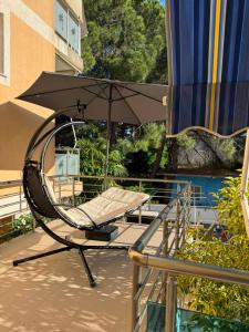 a chair with an umbrella on a balcony at Rezidenca Mabel in Velipojë