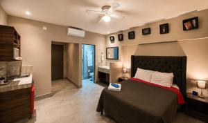 a bedroom with a bed and a bathroom with a ceiling fan at Barrio Inn Morelos in Monterrey