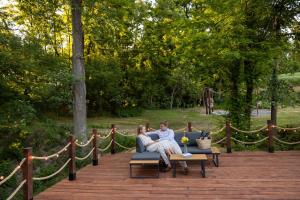 a man and woman sitting on a couch on a bench at Sandomierskie Szepty Lasu - Glamping Sandomierz in Gałkowice