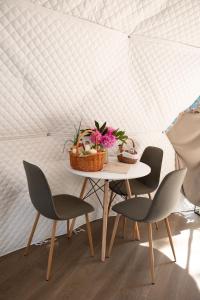 a table with two chairs and a basket of flowers at Sandomierskie Szepty Lasu - Glamping Sandomierz in Gałkowice
