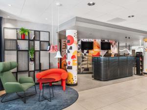 a lobby with a red chair and a desk at Ibis Budapest Centrum in Budapest