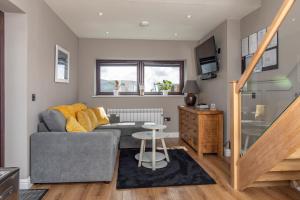 a living room with a couch and a table at Am Bothan - Pied-à-terre in Portree