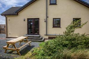 a wooden bench in front of a house at Am Bothan - Pied-à-terre in Portree